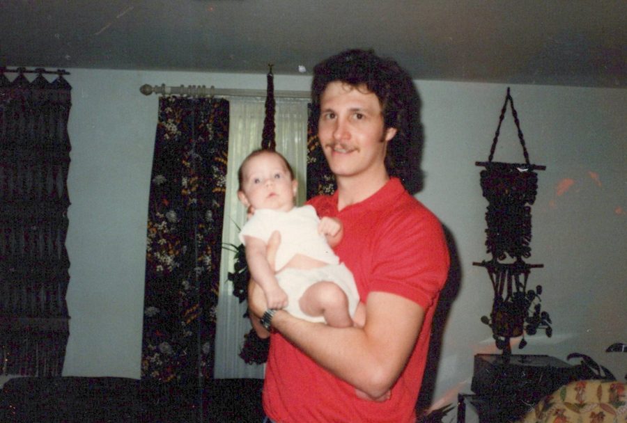 Mike in a red shirt holding baby Shane